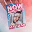Photocard Holder with a person's face and text 'NOW THAT'S WHAT I CALL MY BIAS' held by a hand against a colorful background.