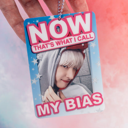 Photocard Holder with a person's face and text 'NOW THAT'S WHAT I CALL MY BIAS' held by a hand against a colorful background.
